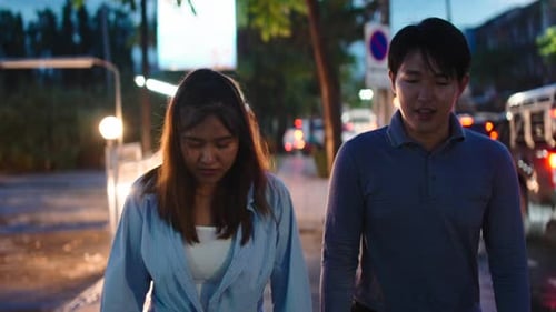 Asian Couple Walking Together During Evening Date Night