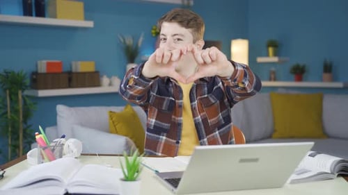 Young Adult Makes Heart Gesture in Home Setting