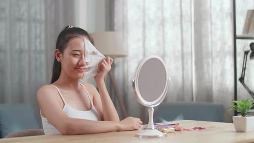 Woman Removes Facial Mask, Smiling in Mirror