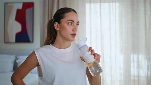 Woman Drinks Water in Modern Apartment