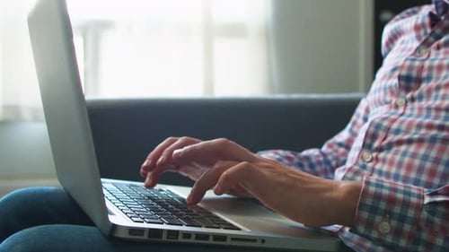 Nahaufnahme der Hände eines männlichen Profis, der an einem Laptop arbeitet
