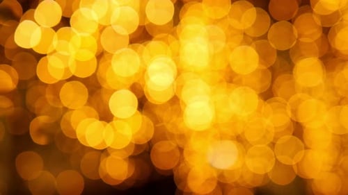 Glowing Yellow Bokeh Lights Against Black Background