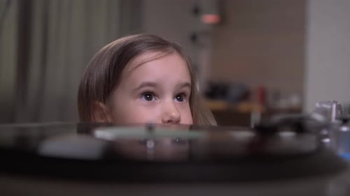 Girl Listens Intently to Spinning Record Player