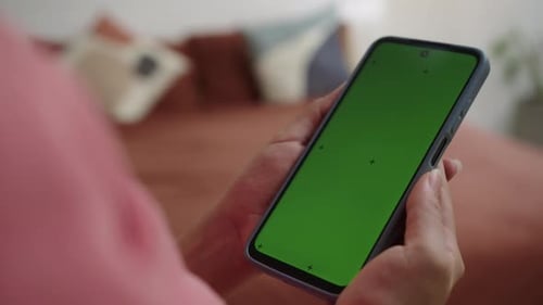 Unrecognizable Person Using Smartphone with Green Screen