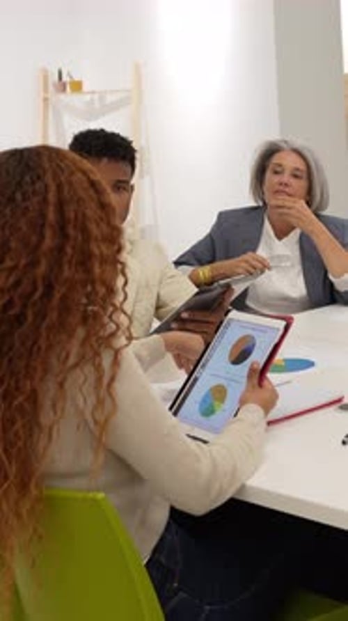 Team Discussing Charts and Graphs at Meeting