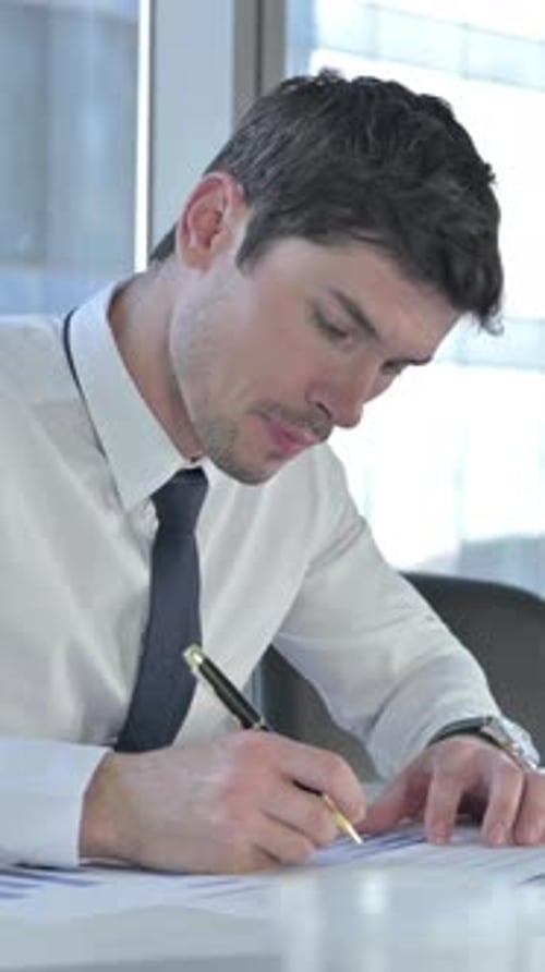 Young Businessman working On Project Documents on Office Desk, vertical video