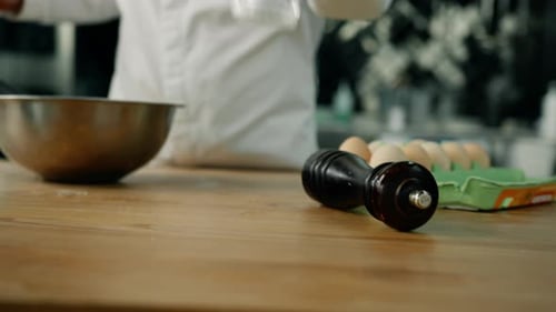 Chef Grinds Pepper in a Kitchen