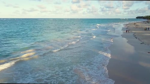 Aereal fly over forward drone shot over bávaro beach high angle looking down gently waves in a calm