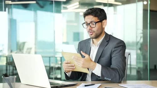 Man Disappointed After Reading Letter in Office