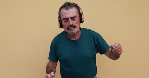 Man Listening to Music and Dancing Against Wall