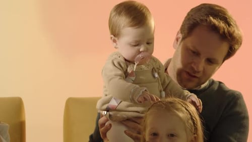 Father Sitting With Infant and Child