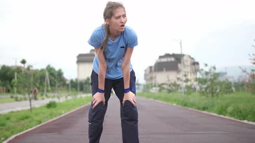 Woman is Breathing Heavily After Jogging in Building Urban Park Young Girl Running Sport Wear Run