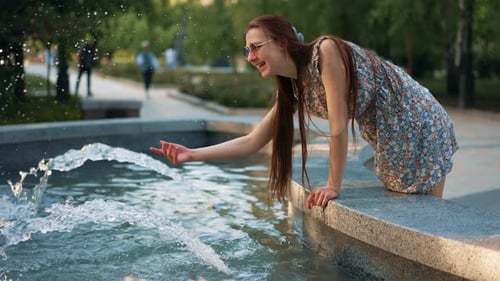Menina espirrando água de uma fonte