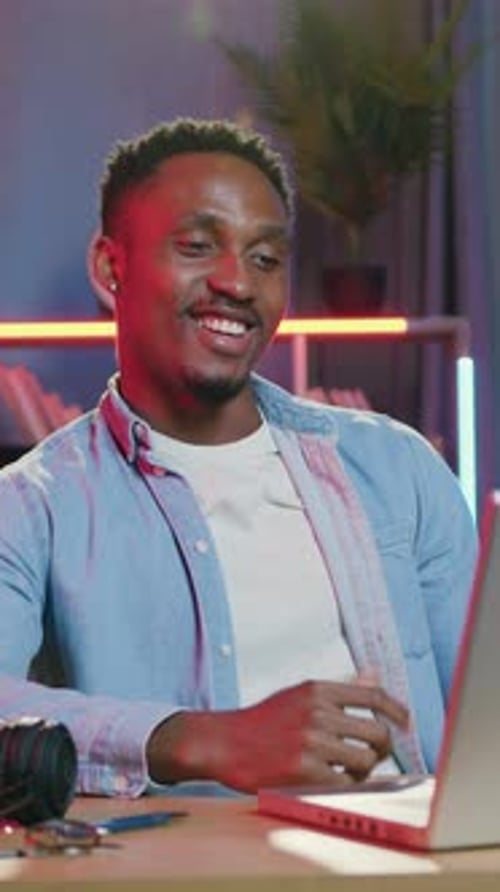 Smiling Man Video Conferencing with Laptop from Home