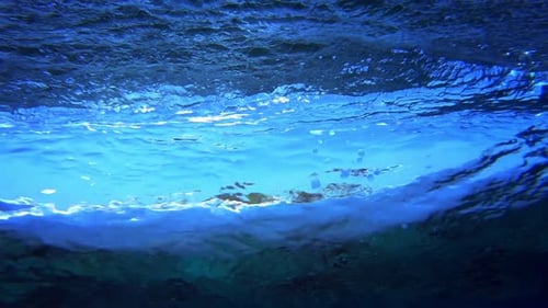 Unterwasserblick auf die Meereswelle, die über dem Riff bricht