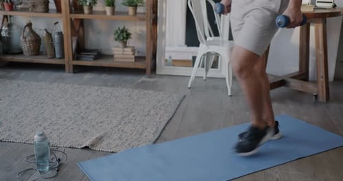 Man Doing Lunges With Dumbbells at Home