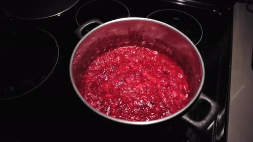 Cranberry sauce cooking on the stove, close up view