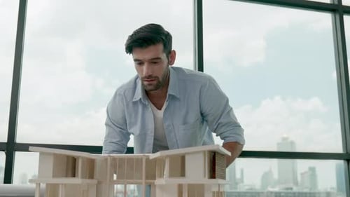 Architect Inspecting Modern Building Model in Urban Office