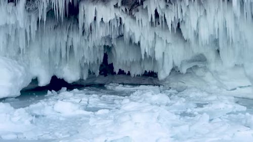 The entrance to the ice cave. Broken icicles. Ice of Lake Baikal in Siberia.