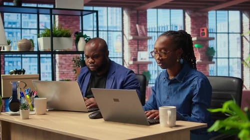 Homme et femme afro-américains travaillant à distance dans leur appartement
