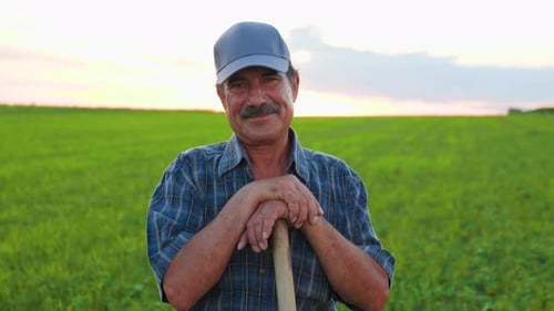 Content Farmer Smiles with Shovel in Grassy Field