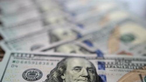 Close-up slow motion shot of 100 dollar bills lying flat on table. Background of money.