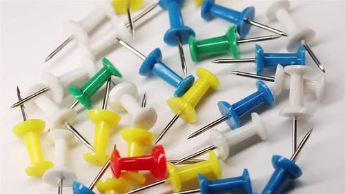 Colorful Push Pins Rotating On White Background. Drawing Pins For Marking
