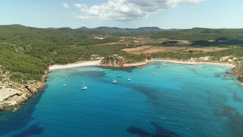 European harbour with sailing yachts moored at sunset. Aerial drone view shows large green mountains