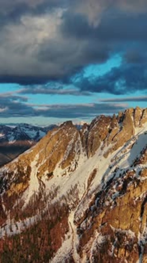 Rocky snow mountains at sunset aerial