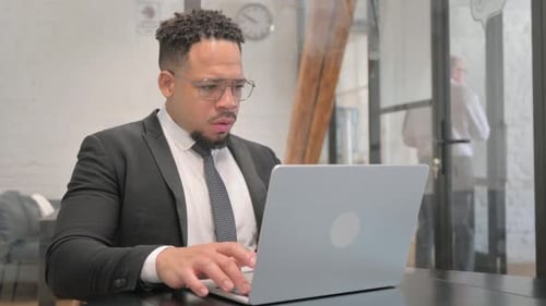 Frustrated Man Working at Computer in Office