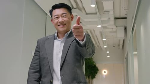 Smiling Man Gives Thumbs Up in Hallway
