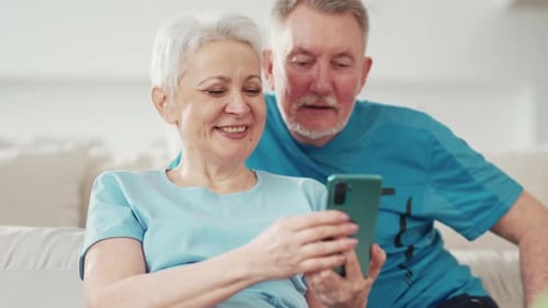 Senior Couple Enjoys Smartphone Together in Living Room
