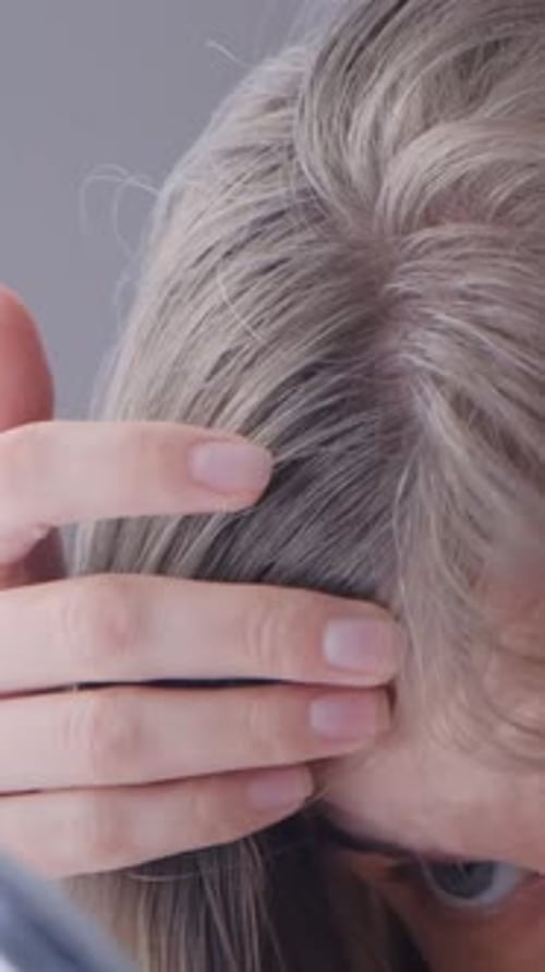 Woman Inspecting Her Hair Roots Close Up