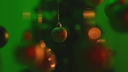 Christmas Tree Golden Green Balls Highlighted By Green Light Hanging From Top Glittering Ornaments