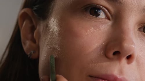 Woman Using Skincare Tool on Face Close Up