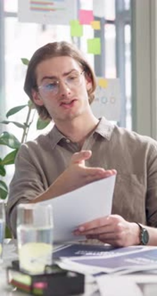 Man Presents Documents in Bright Office Space