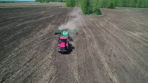 Aerial View of an Agricultural Tractor Performing Plowing Tillage for Sowing Crops A Cultivator