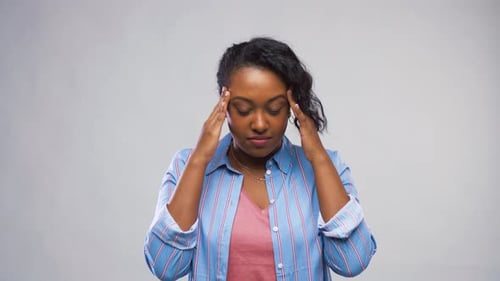 Woman Holding Head with Hands in Studio Backdrop