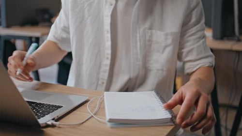 Menschliche Hände, die am Schreibtisch Notizen machen, Nahaufnahme, Programmierer, Tippen, Laptop-Tastatur
