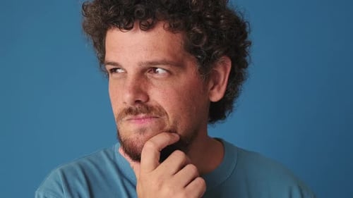 De cerca, hombre tomando decisiones, teniendo una idea, aislado sobre fondo azul en el estudio