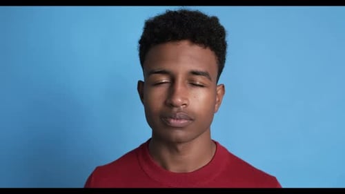 Young Boy Opening His Eyes on a Blue Background