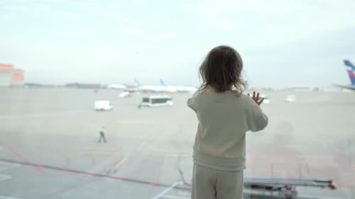 Preschooler Girl Watches with Interest Passengers Arrive at Plane