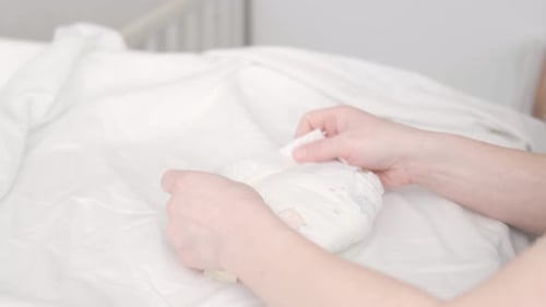 Mom Folds Used Diaper to Throw It in the Trash Mother Changes Diapers to Her Newborn Baby on