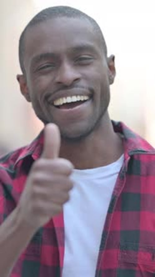 Smiling Man Gives a Thumbs Up of Approval