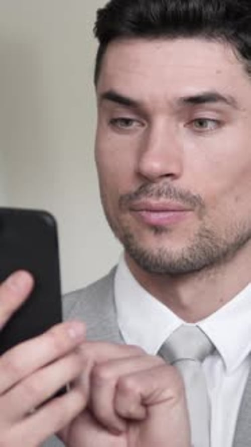 Excited Man Reacts to News on His Smartphone