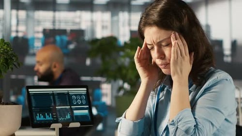 Woman Suffering Headache Reaches for Aspirin at Work