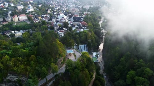 Drone footage of Jajce waterfall at sunrise in Bosnia and Herzegovina. Aerial view of city
