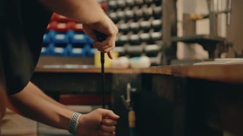 Male hands press golf club shaft down on ground for custom fitting in workshop in slow motion