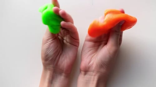 Playing with Textured Slime with Bubbles Stretching the Gooey Substance Female Teen Hand Holding