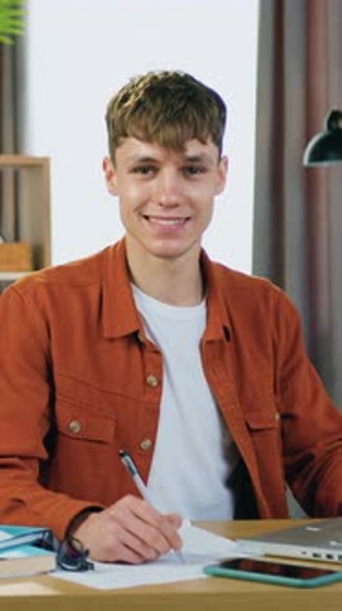 Smiling Young Man Studying at Desk Indoors